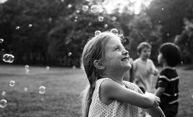Children is playing bubbles in a park stock photos Children is playing bubbles in a park stock photos