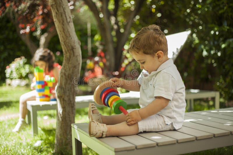 Children Playing with Construction Toys in the Garden Stock Image