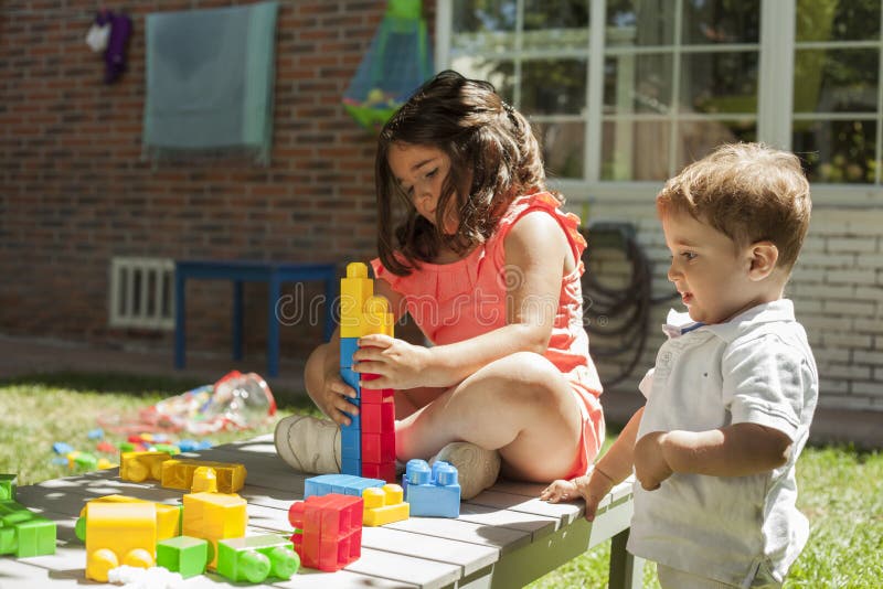 Children Playing with Construction Toys in the Garden Stock Photo