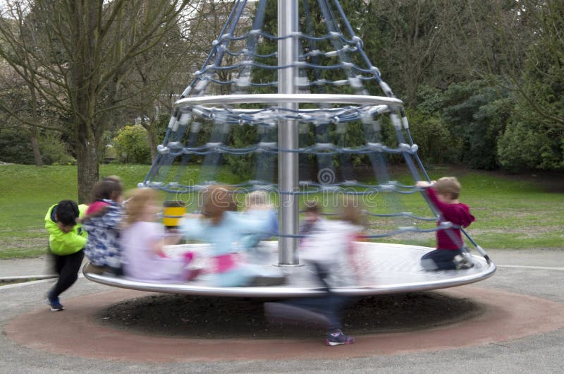Children playing merry go round