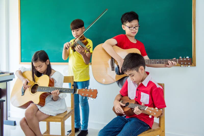 Children playing music instruments in music classroom