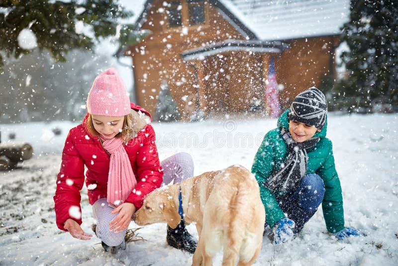 Children playing with snow and dog