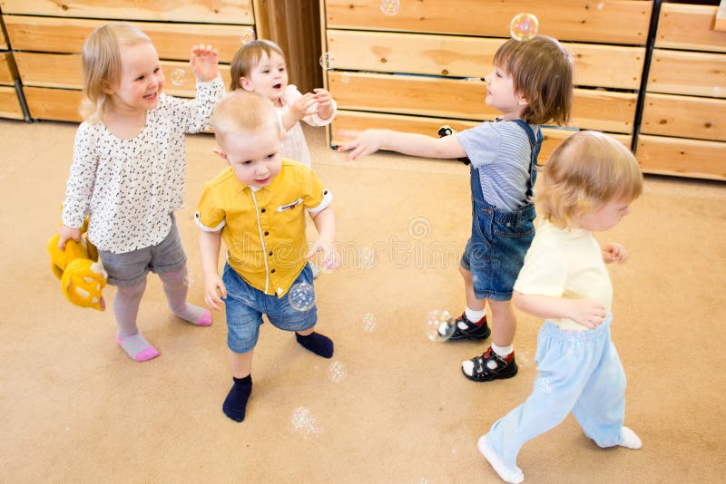 Children Playing with Soap Bubbles in Kindergarten Stock Photo Image