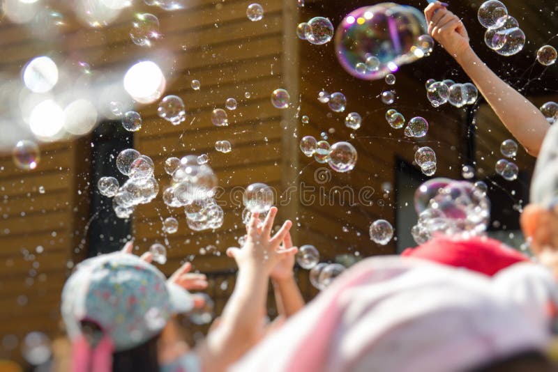 Children Playing with Soap Bubbles in Kindergarten Outdoor Stock Image