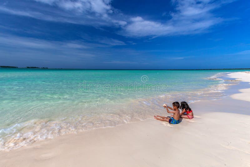 Children playing on white sandy Cuban beach in Cayo Coco