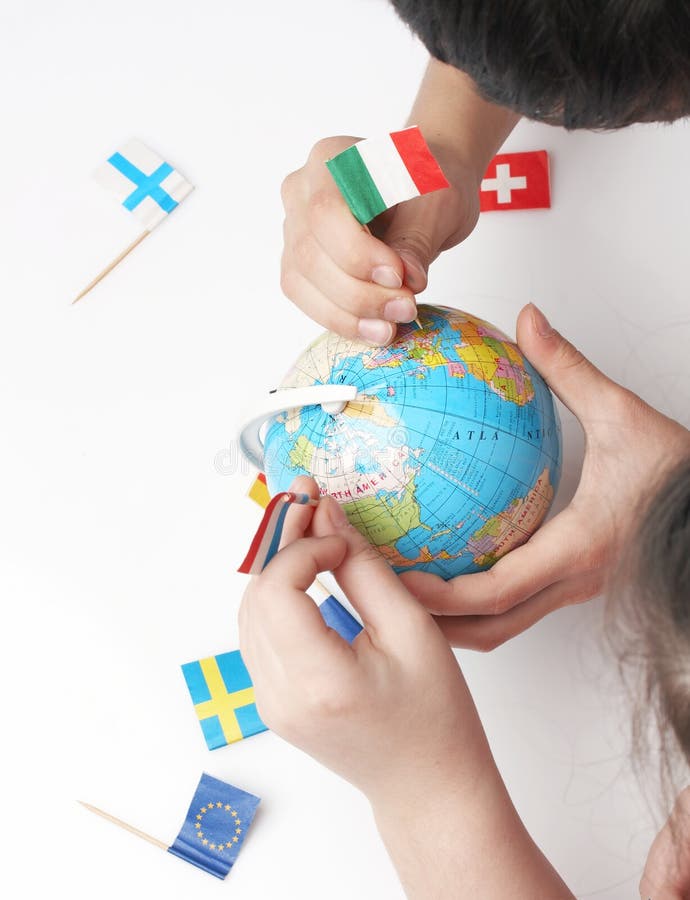 Children pointing flags on world globe