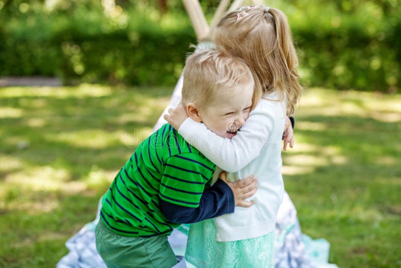 Children Preschoolers Embrace and Play in the Park. Girl and Boy Stock ...