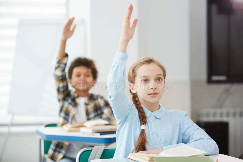 Children Raising Hands in School stock photo