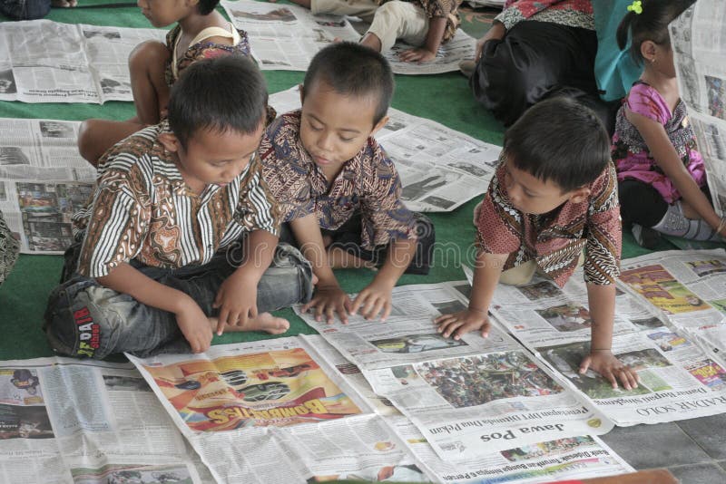 CHILDREN READING A NEWSPAPER ON A NATIONAL PRESS