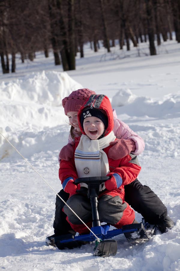 Children ride a snow-scooter