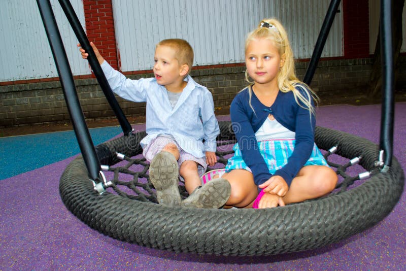 Children ride on a swing stock photo. Image of female 42759986