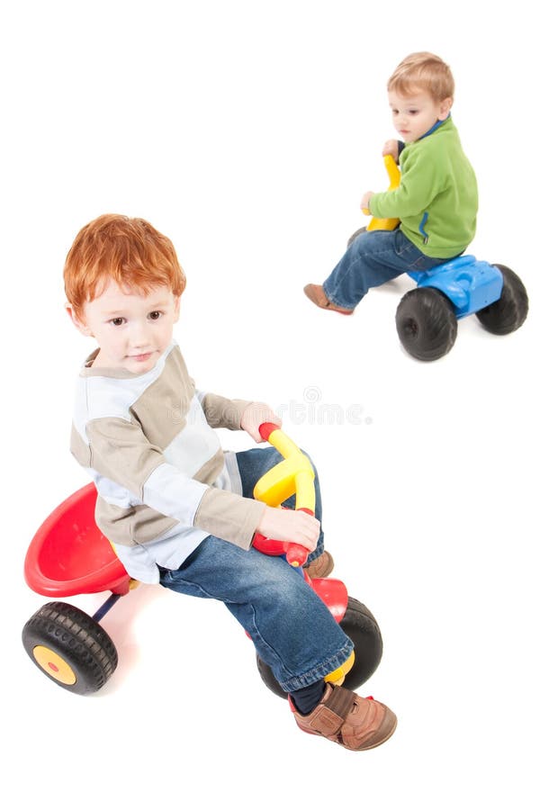 Boys riding kids tricycles. Isolated on white. Boys riding kids tricycles. Isolated on white.