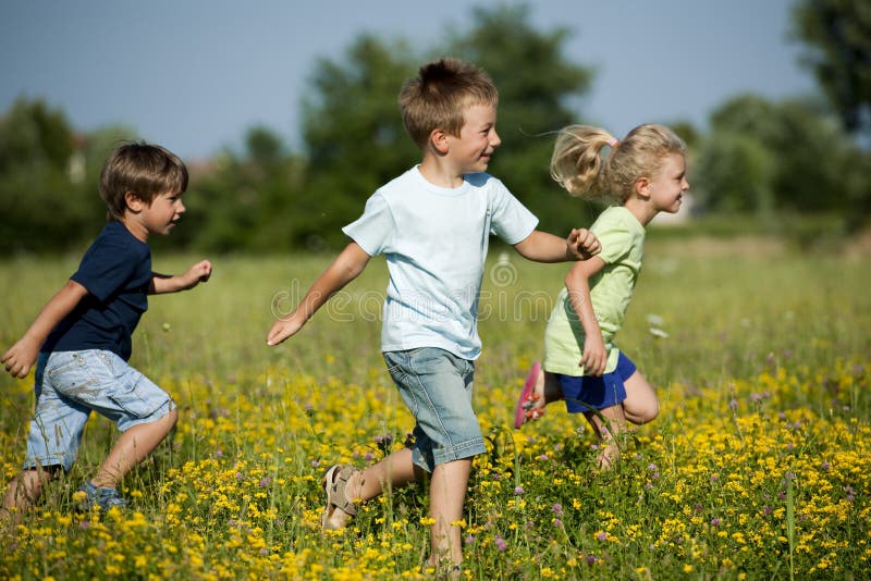 Three cute children running outdoors
