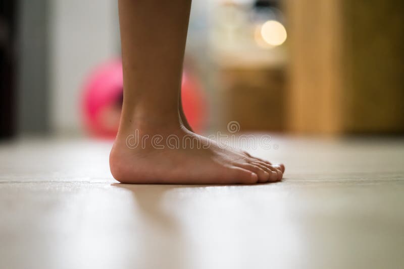 Children`s bare feet. Child`s bare feet on the wooden floor