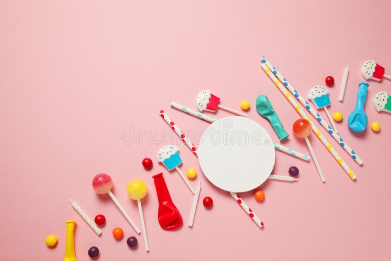 Children`s birthday pink background. Scattered colorful candies, balls, candles and straws royalty free stock photography Children`s birthday pink background. Scattered colorful candies, balls, candles and straws royalty free stock photography