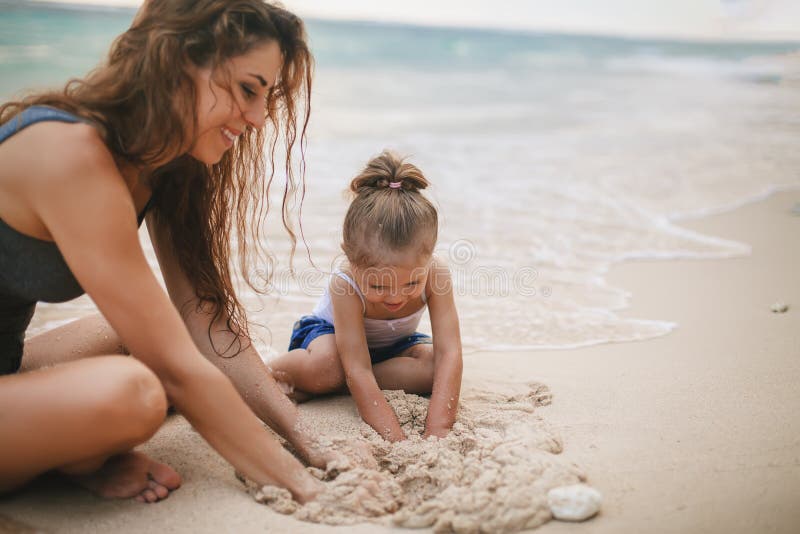 Children`s Day. Mom and baby playing near beach.