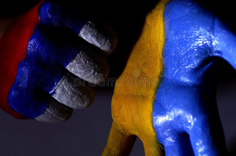 Children`s hands are painted color of a flag of Ukraine and Russia.Ukraine and Russia