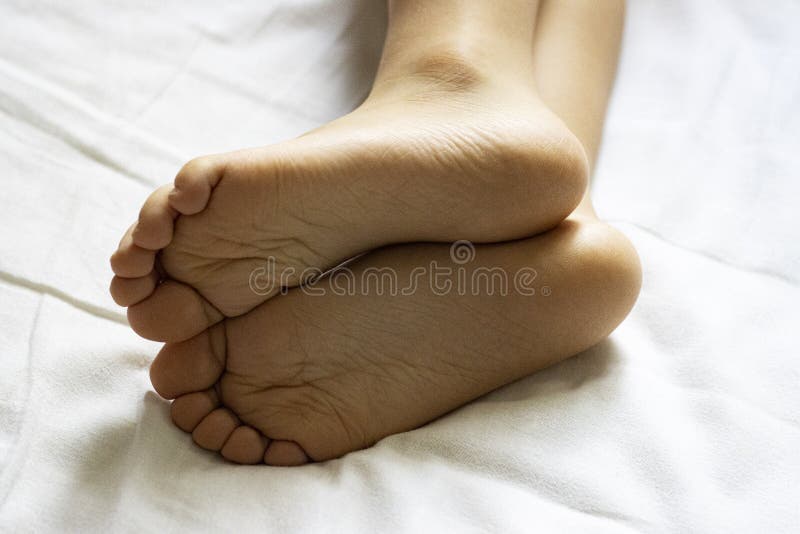 Children`s heels on a white bed close-up