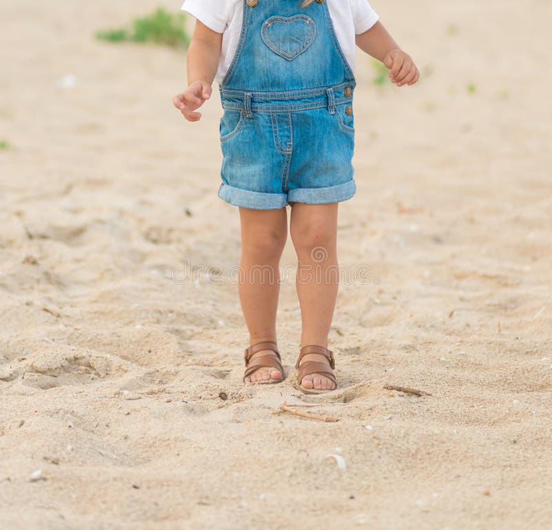 Children`s legs in summer shoes made of genuine leather