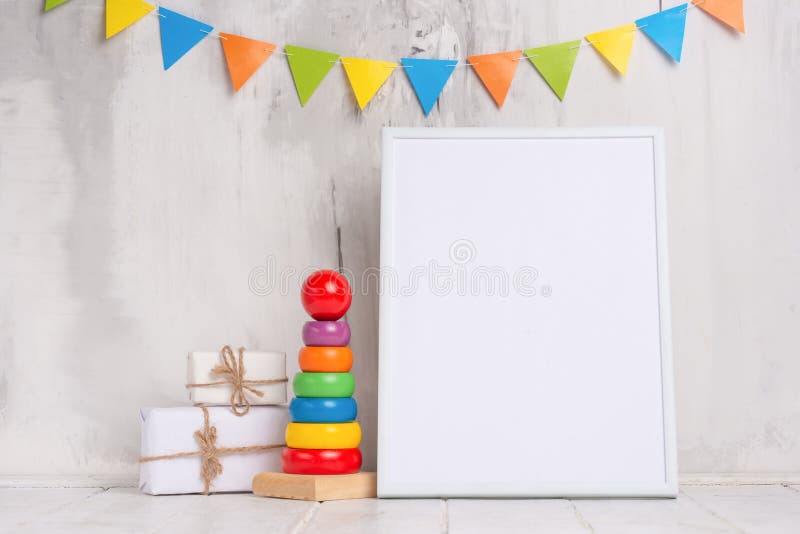 Children`s toys, with a white frame The frame on a light background of the wall with children`s signs, for design, layout. Baby shower,