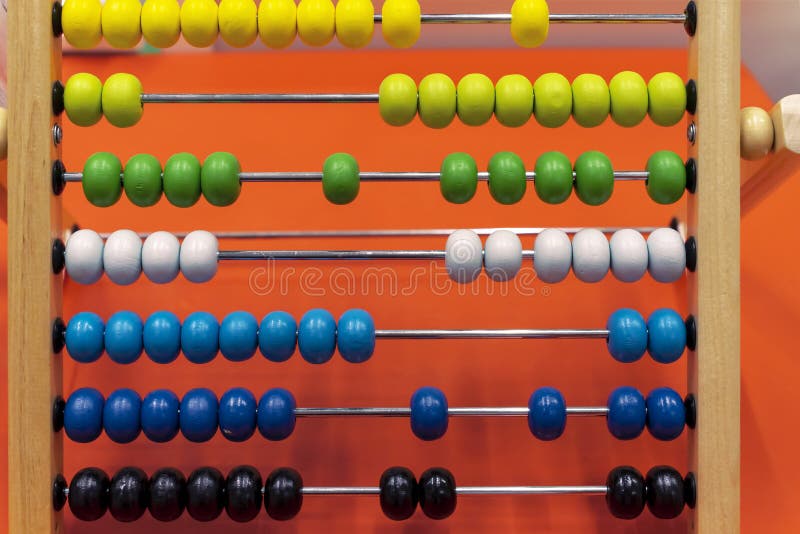 Children`s wooden abacus on an orange background royalty free stock image
