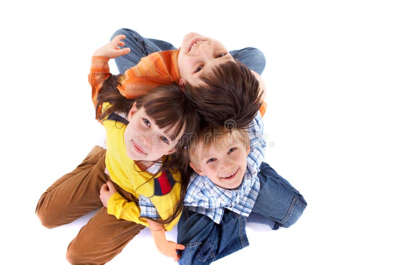 A top-down shot of three cheerful children, sitting back to back with their arms linked. Isolated on white. Top smiling cheerful stock images, royalty-free photos and pictures