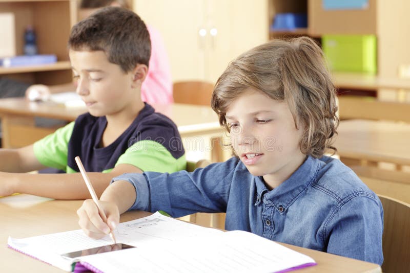 Children are sitting in the classroom stock images