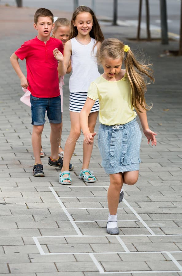 Portrait of playful children skipping together hopscotch on urban playground. Portrait of playful children skipping together hopscotch on urban playground