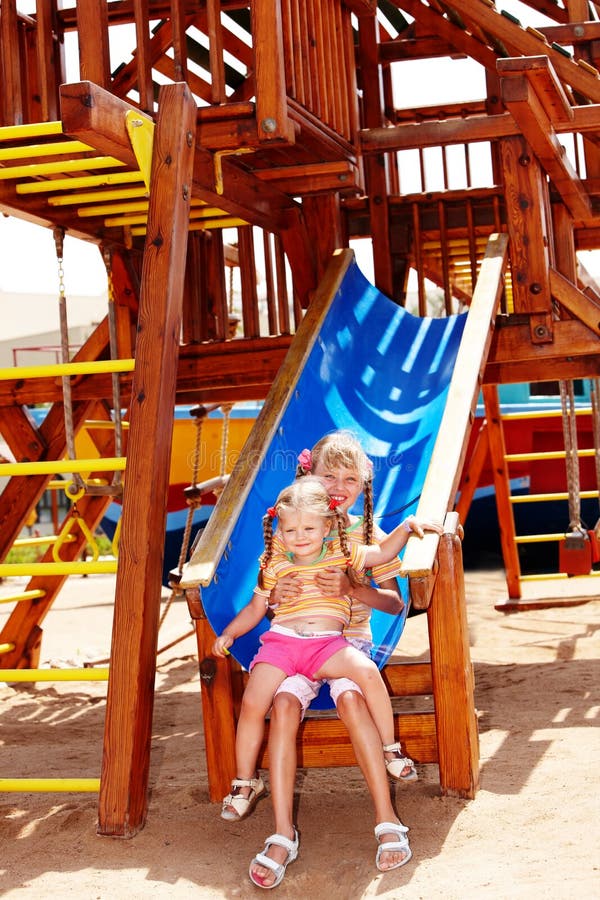 Children girl on slide in playground. Outdoor park.