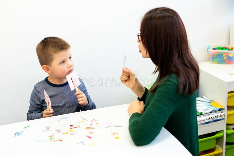 Children speech therapy concept. Preschooler practicing correct pronunciation with a female speech therapist.