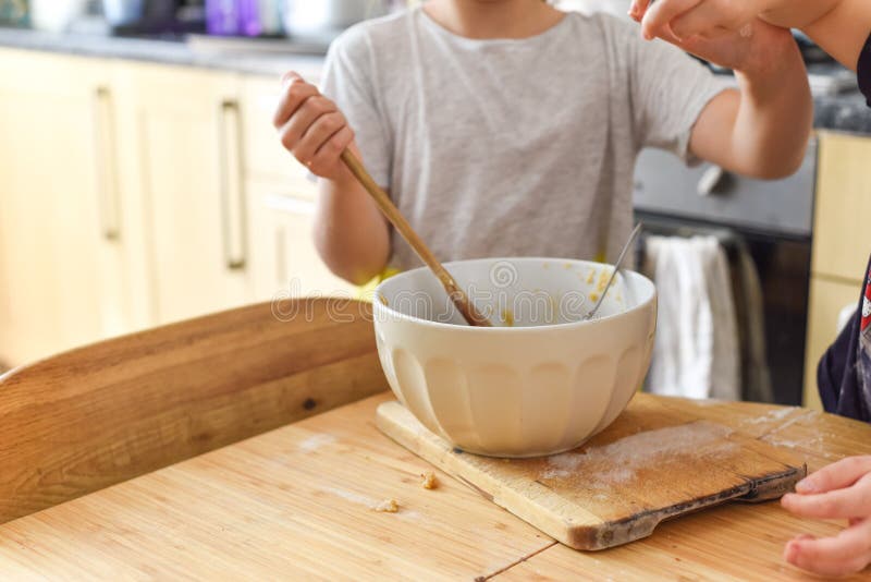 Children Stir a Mixing Bowl in the Kitchen at Home while Baking Cookies