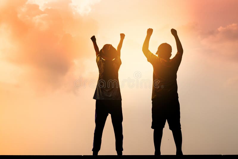 2 children stood up, raised hands, happy