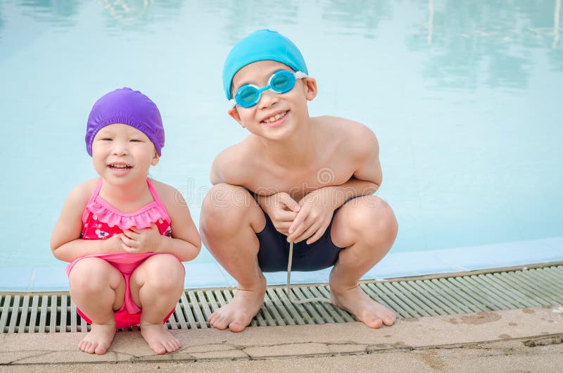 Young boy and girl in swim suit sitting at swim pool. Young boy and girl in swim suit sitting at swim pool