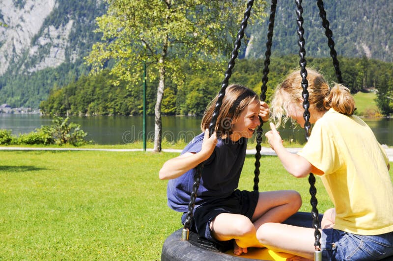 Children on swing at lakeside park