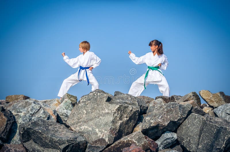 Children training karate on the stone coast royalty free stock photography Children training karate on the stone coast royalty free stock photography
