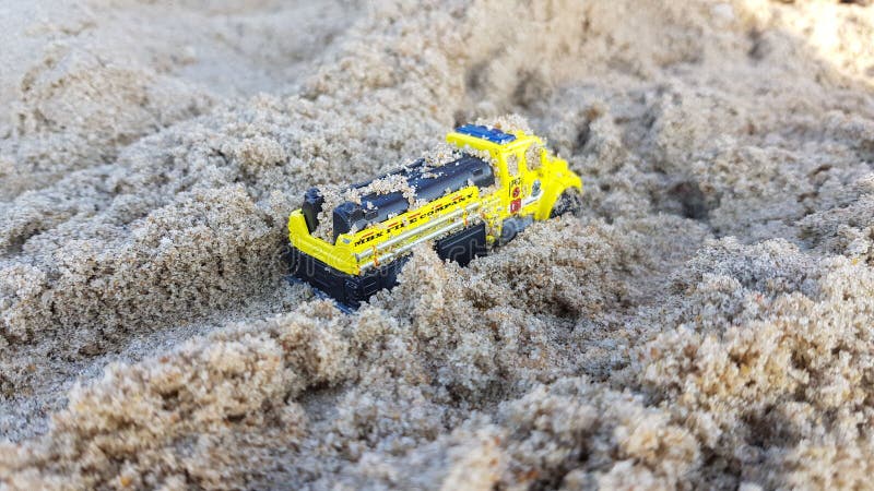 Children yellow car toy model in sand royalty free stock images Children yellow car toy model in sand royalty free stock images