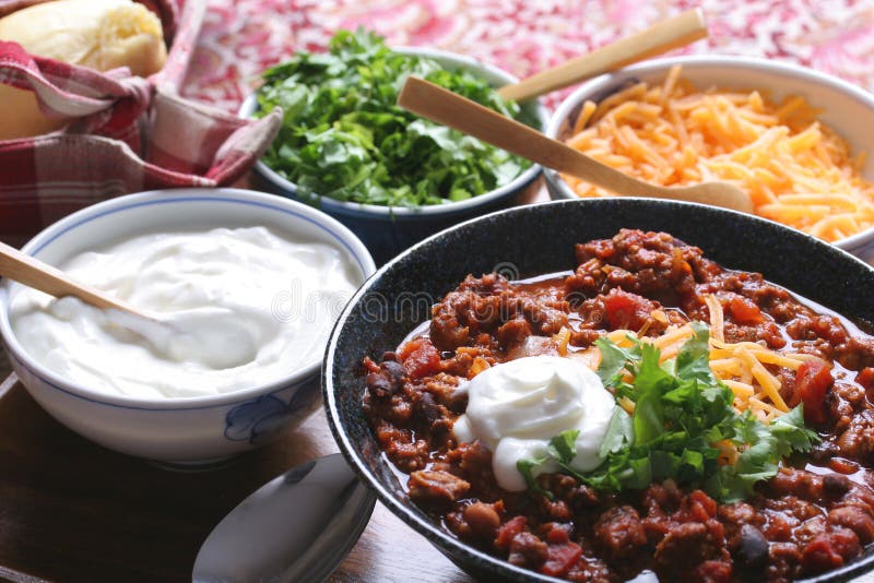 Chili with cheese, sour cream, cilantro and homemade roll. Chili with cheese, sour cream, cilantro and homemade roll