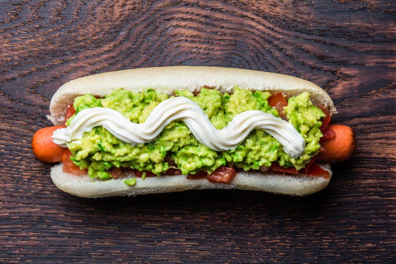 Chilean Completo Italiano. Hot dog sandwiches with tomato, avocado and mayonnaise on wooden board. Top view, copy space