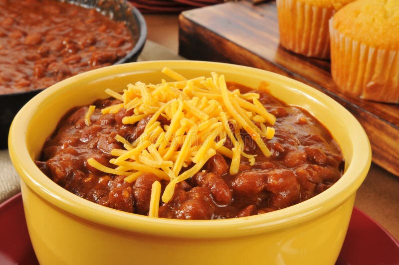 A bowl of chili con carne with shredded cheddar cheese