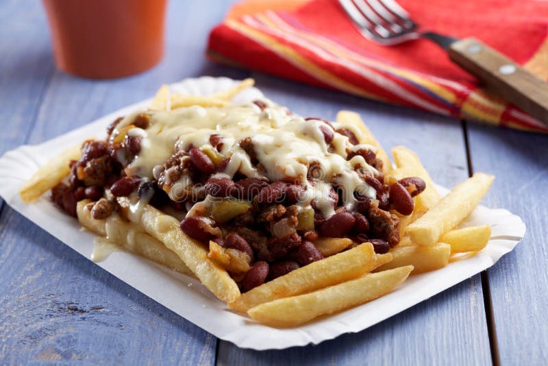 Chili con carne and French fries on a paper plate. Chili con carne and French fries on a paper plate