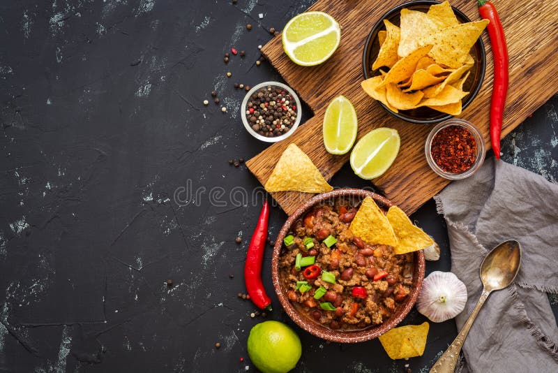 Chili con carne con i chip dei nacho su fondo rustico Alimento messicano Posto per testo, vista superiore
