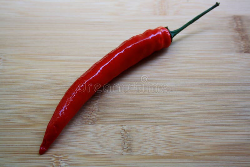 Chili Pepper candente en fondo de madera imagen de archivo libre de regalías Chili Pepper candente en fondo de madera imagen de archivo libre de regalías