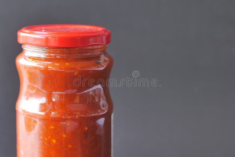 Chili Tomato Sauce in a Small Jar Against Black Background Stock Image