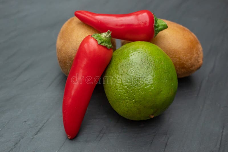 Chilies, kiwier och limefrukt på kritiserar fotografering för bildbyråer Chilies, kiwier och limefrukt på kritiserar fotografering för bildbyråer