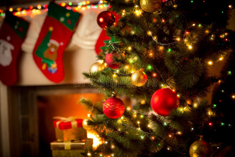 Chimenea y árbol de navidad adornados en la cabaña