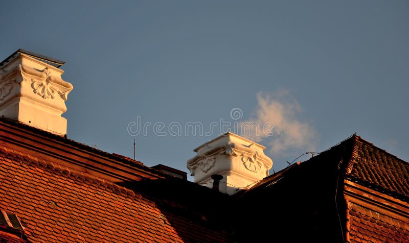 Chimney on the building of the castle roof with a beautiful rococo stucco decoration. light smoke from a gas boiler is smoked from