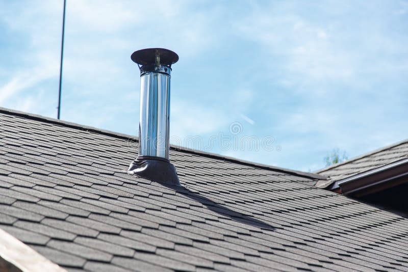 Chimney pipe from stainless steel on the roof of the house.