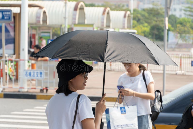 China, Guangzhou - 19. Oktober 2019: Zwei Mädchen aus Asien, eine in einem schwarzen Hut und ein Regenschirm vor der Sonne, die a stockfoto China, Guangzhou - 19. Oktober 2019: Zwei Mädchen aus Asien, eine in einem schwarzen Hut und ein Regenschirm vor der Sonne, die a stockfoto