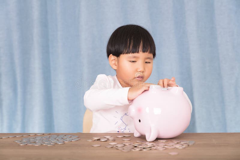 Chinees meisje dat speelt met een roze spaarpot stock foto