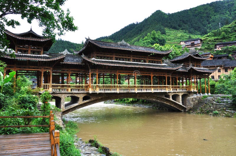 The gallery bridge, which is made of wood, is located in Miao ethnic minority village ( or Villages of Thousands of Miao House-holds) in Xijiang,Kaili,Guizhou,China. The gallery bridge, which is made of wood, is located in Miao ethnic minority village ( or Villages of Thousands of Miao House-holds) in Xijiang,Kaili,Guizhou,China.